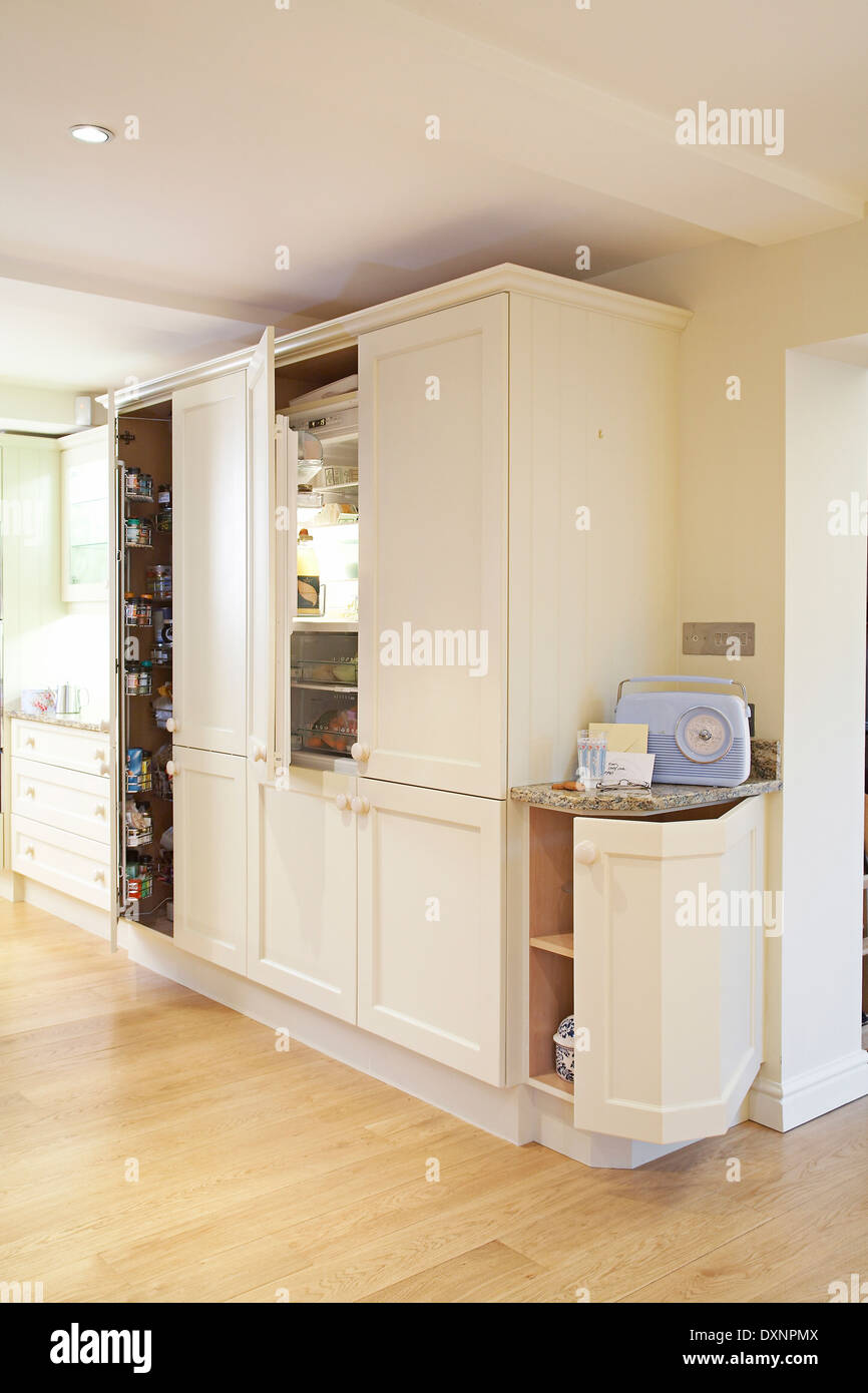 Modern cream kitchen units and open cupboards and fridge showing