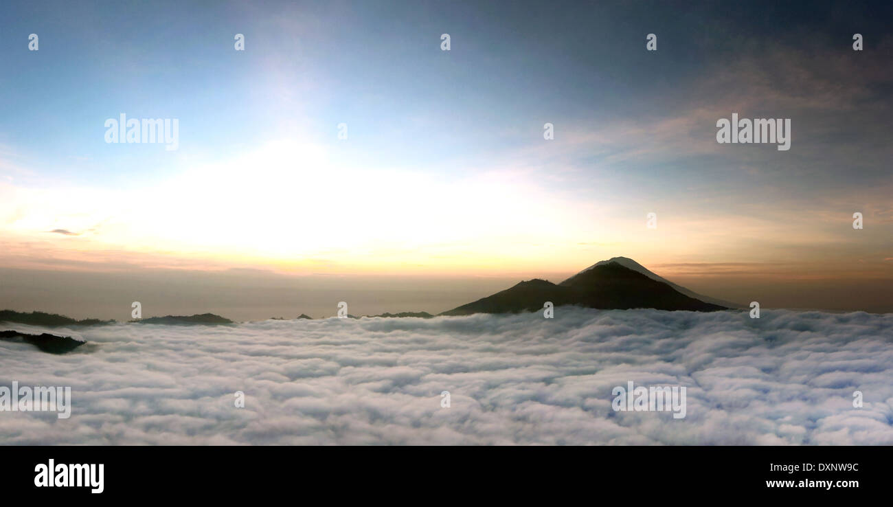Sunrise above clouds with a mountain volcano view. Mt. Batur Bali ...