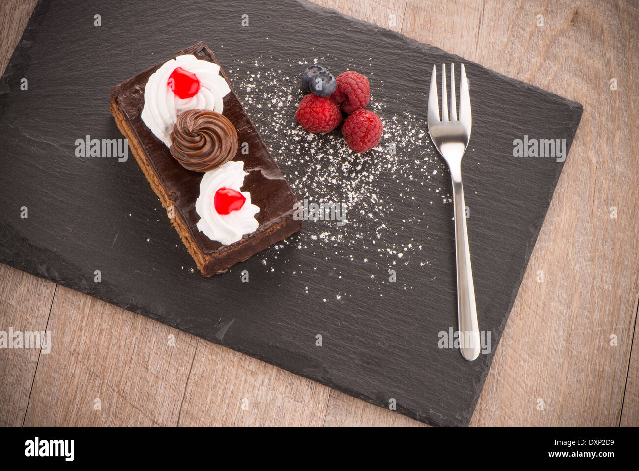 Piece of chocolate cake with berries on dark slate tray Stock Photo - Alamy