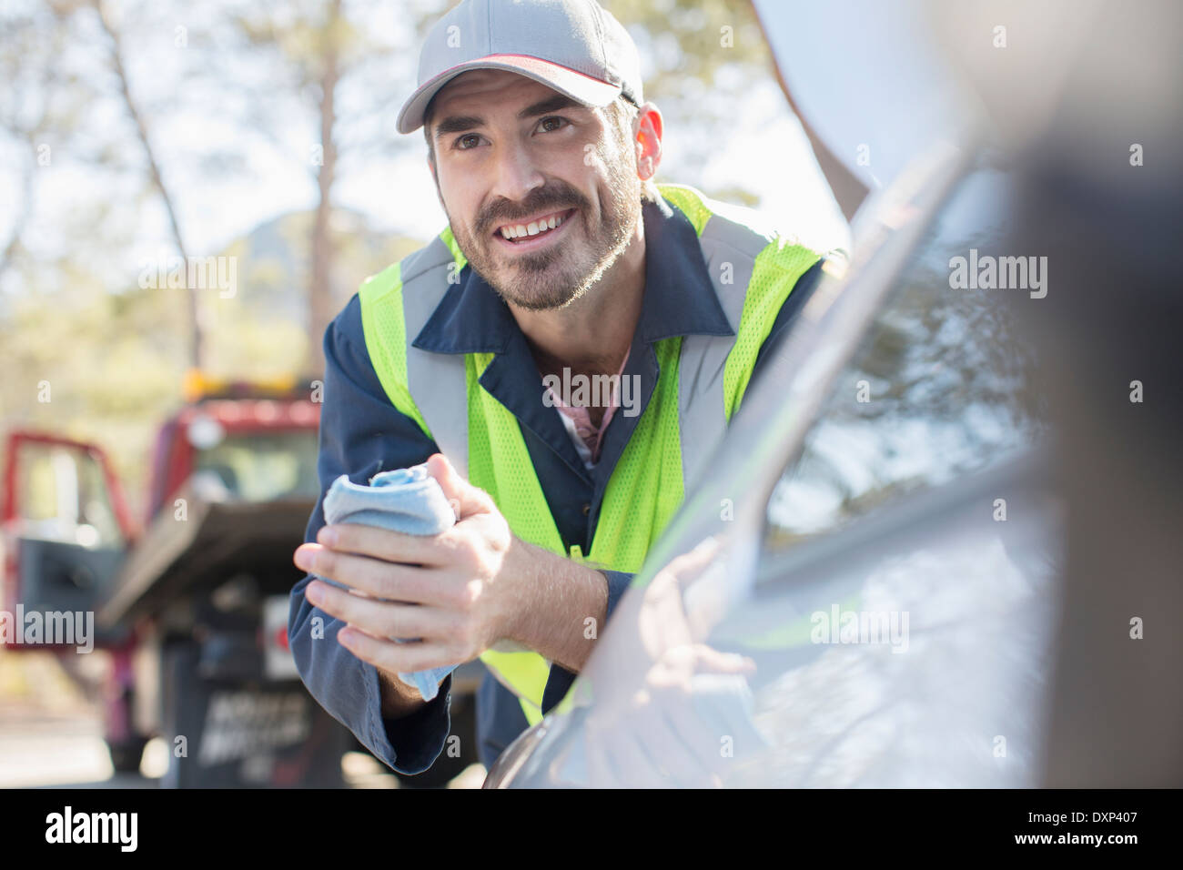 Roadside mechanic leaning on car Stock Photo