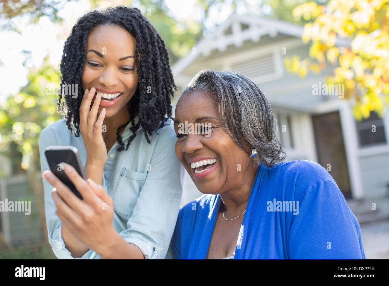 Mother and daughter looking at cell phone and laughing Stock Photo