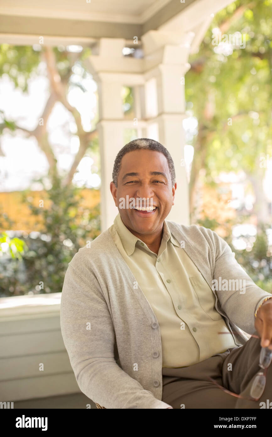 Portrait of laughing senior man on porch Stock Photo