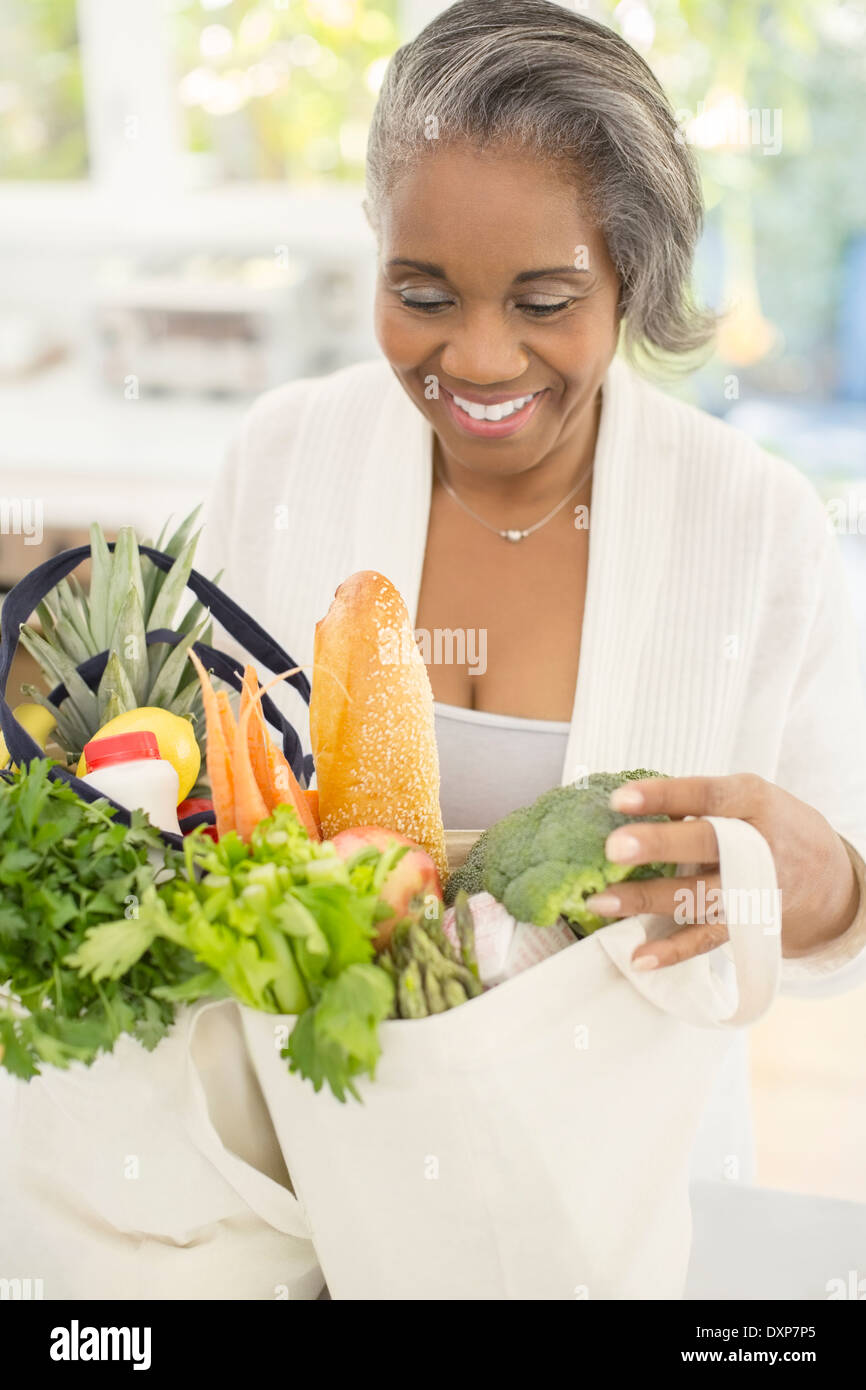 Happy senior woman unpacking groceries Stock Photo