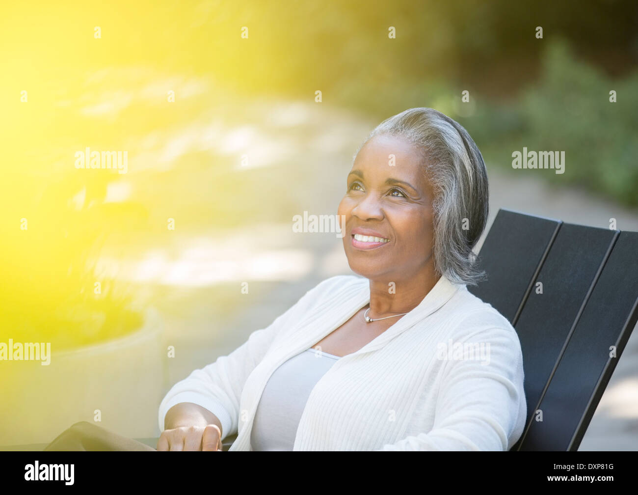 Happy senior woman sitting on patio Stock Photo - Alamy