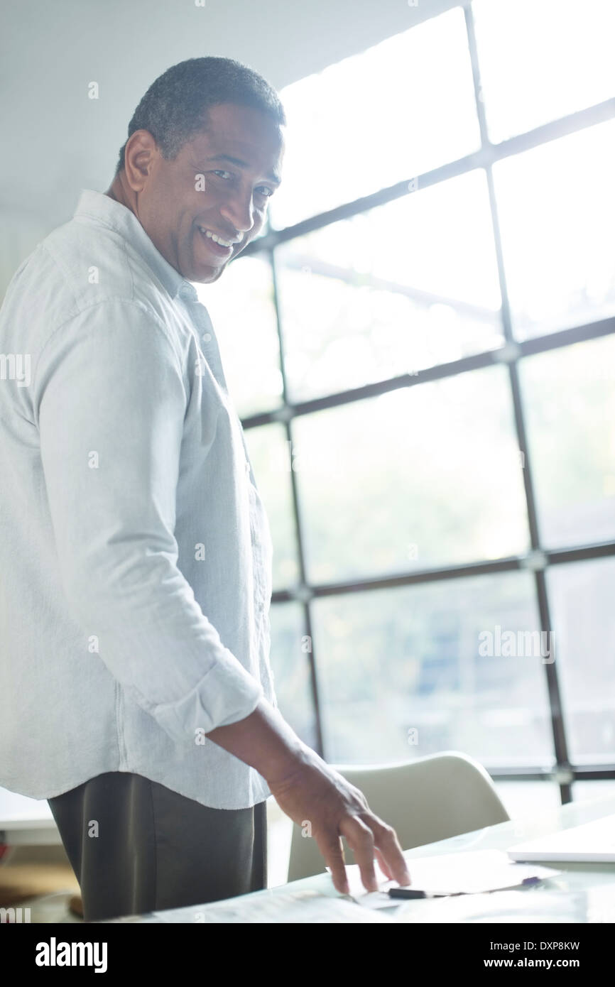 Portrait of smiling senior man at desk Stock Photo