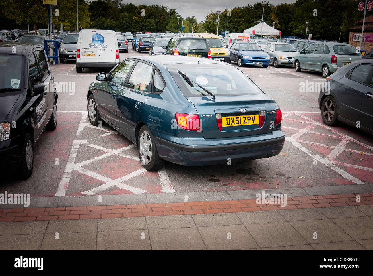 Badly parked car in disabled bay in supermarket car park Stock Photo