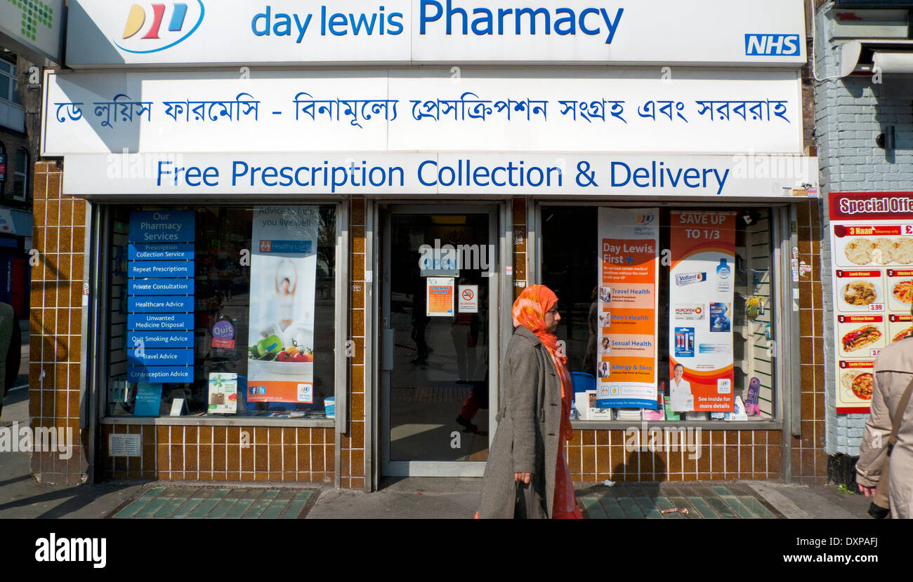 Muslim woman walking past day lewis Pharmacy exterior on Whitechapel Road in East London E1, UK KATHY DEWITT Stock Photo