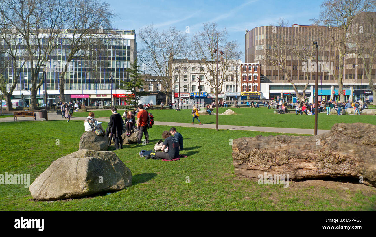 People relaxing in Altab Ali Park on a sunny March day in Whitechapel East End London, UK KATHY DEWITT Stock Photo