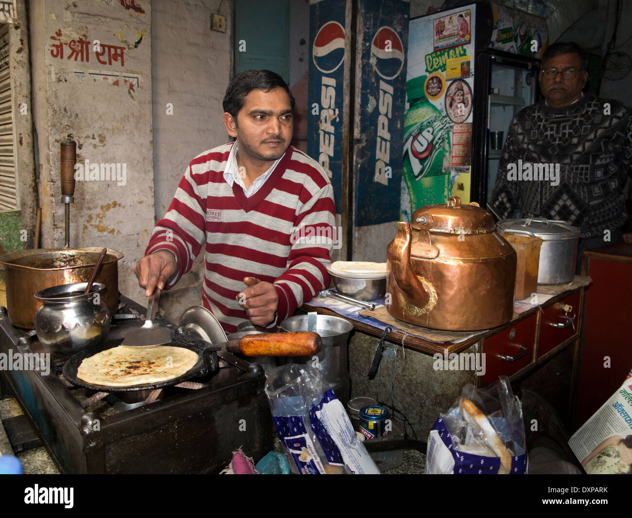 India, Punjab, Amritsar, street food, man cooking paratha on tava at roadside cafe Stock Photo