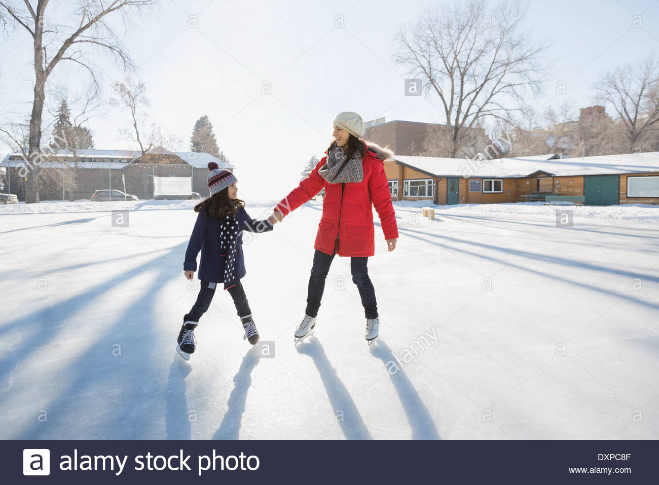 Mother and daughter ice-skating on rink Stock Photo