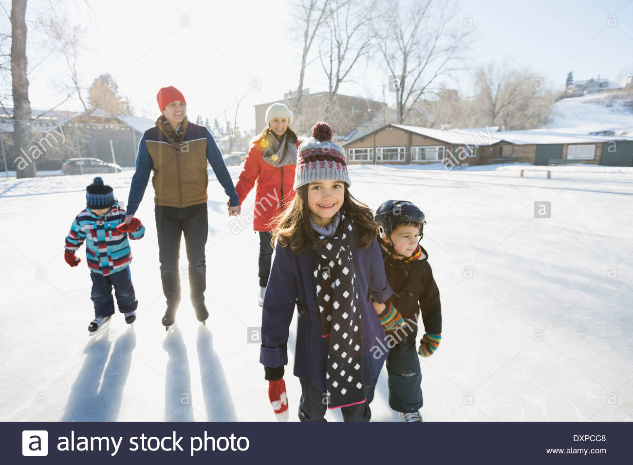 Family ice-skating on outdoor rink together Stock Photo