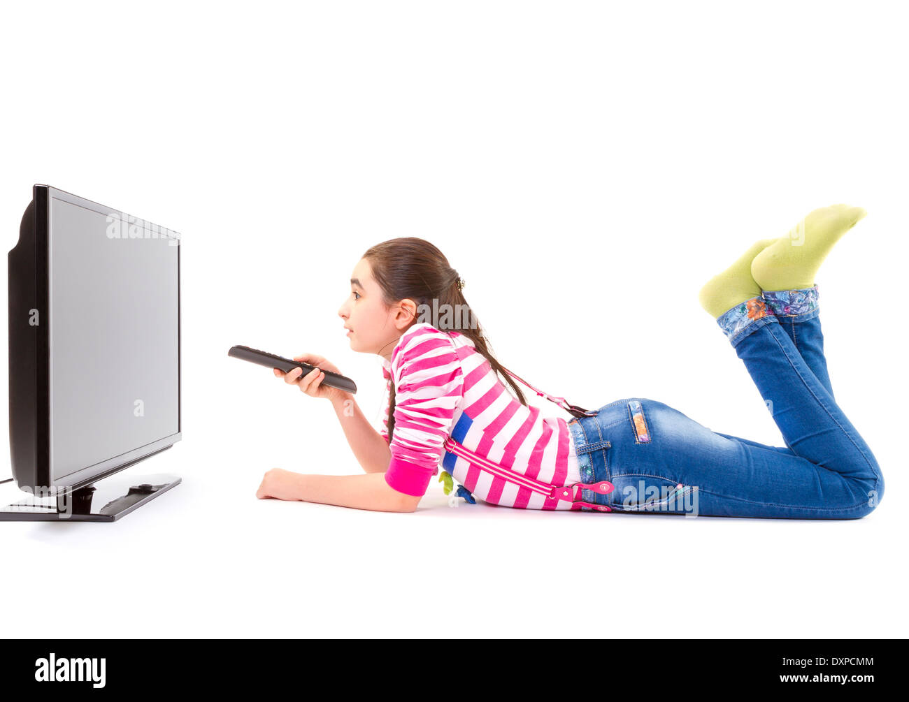 Happy little girl laying down and watching tv Stock Photo