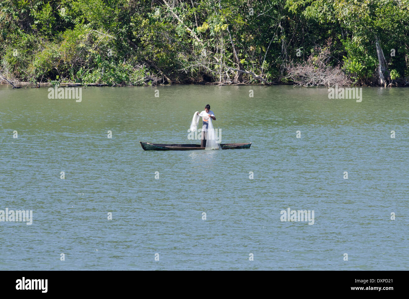 Guatemala, Department of Izabal, Rio Dulce (Sweet Water River) near Livingston. Traditional fishermen in wooden boat with net. Stock Photo