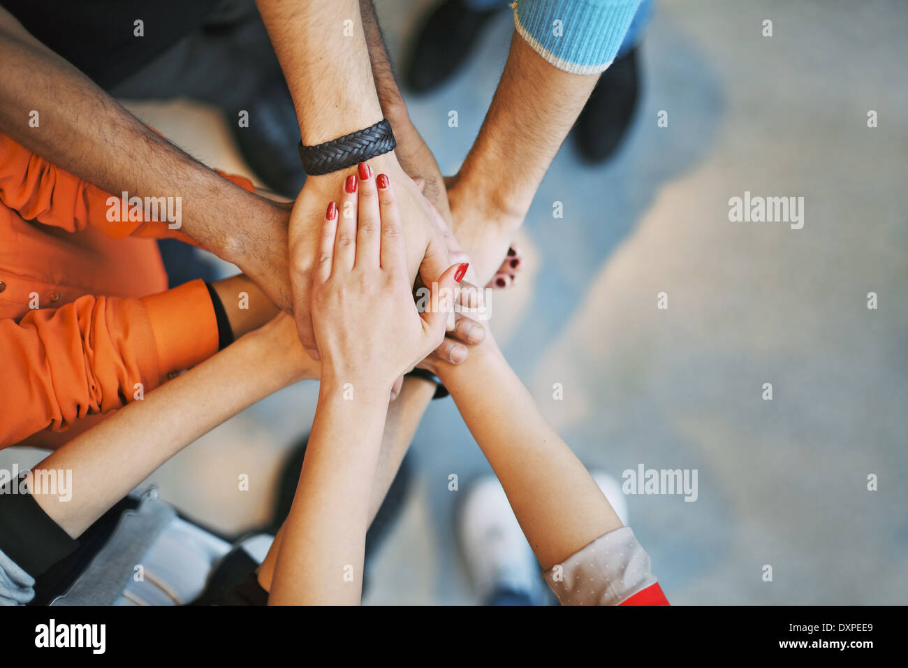 Multiethnic group of young people putting their hands on top of each other. Close up image of young students stacking hands. Stock Photo