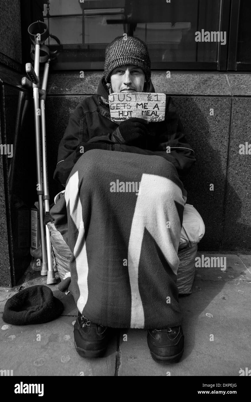 Homeless Man Holding A Sign On The Streets Of London With A Pair Of Crutches Next To Him Stock Photo Alamy