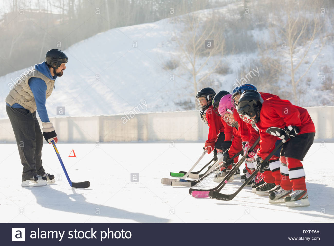 Coach training ice hockey players on rink Stock Photo Alamy