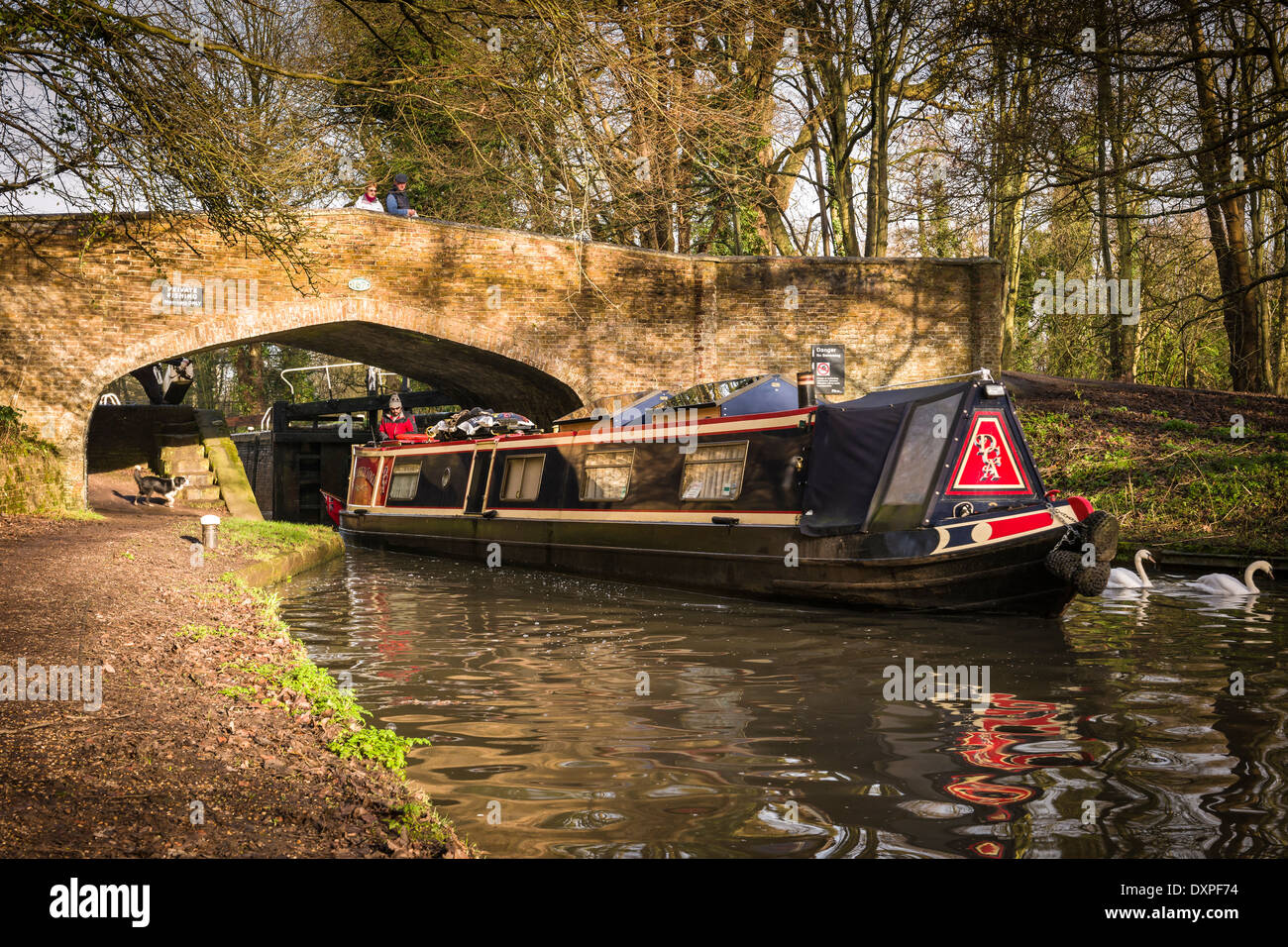 A barge passes under a bridge on the Grand Union Canal in Cassiobury Park, Watford, England. Stock Photo
