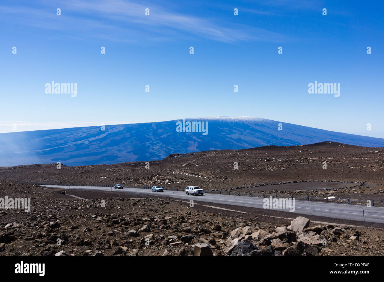 Cars on Mauna Kea summit road. Mauna Loa in background. Big Island of