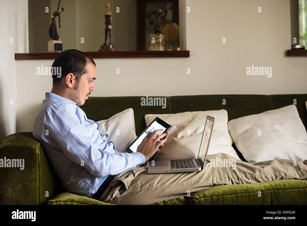 Man Using Devices elegant business multitasking multimedia man using devices at home ...