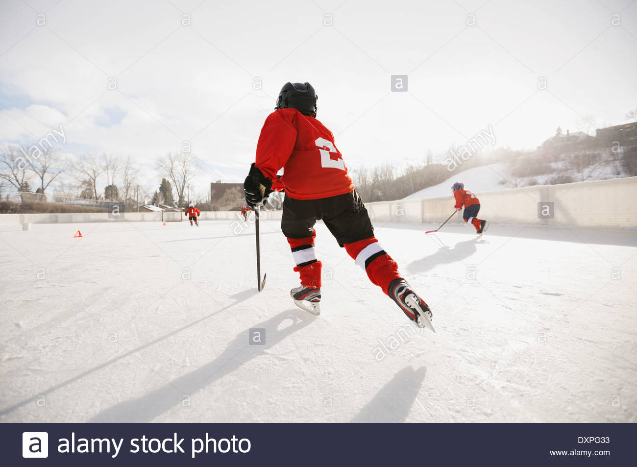 Rear view of boy playing ice hockey on rink Stock Photo
