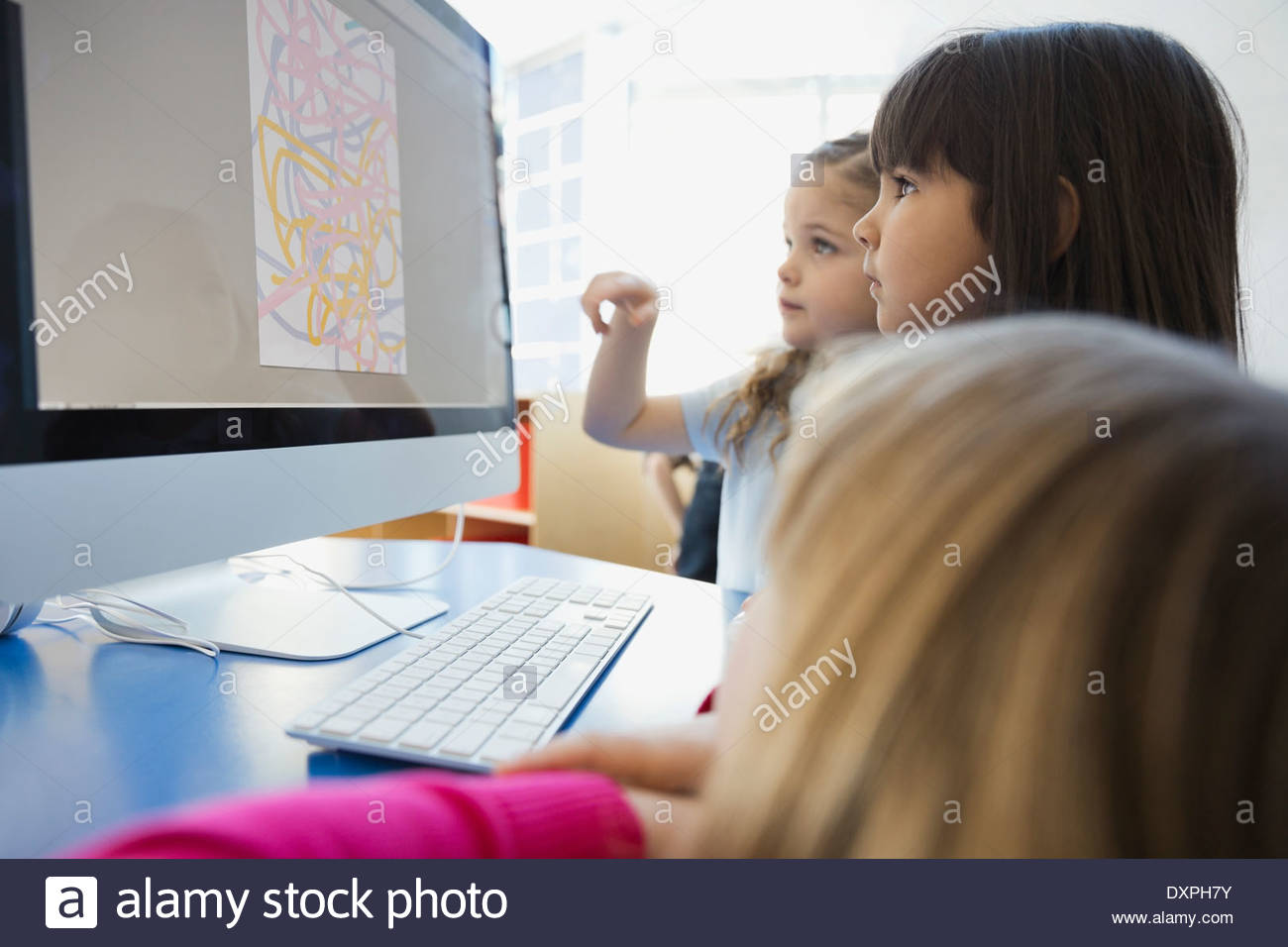 Girls drawing on computer in school Stock Photo