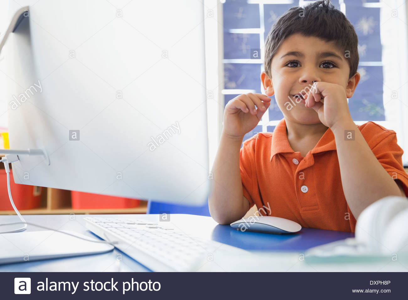 Cute boy sitting at computer desk in elementary school Stock Photo Alamy