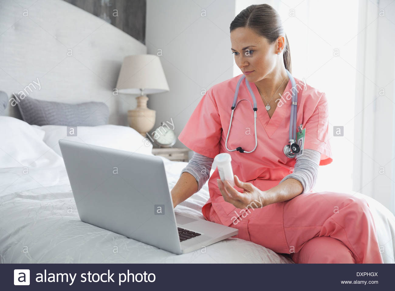 Home nurse using laptop to verify prescription Stock Photo