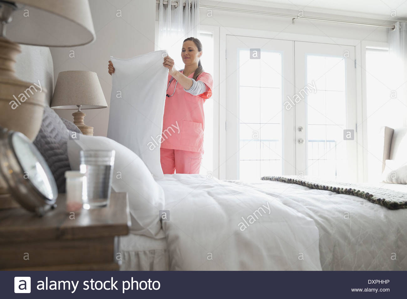Home nurse making patients bed Stock Photo Alamy