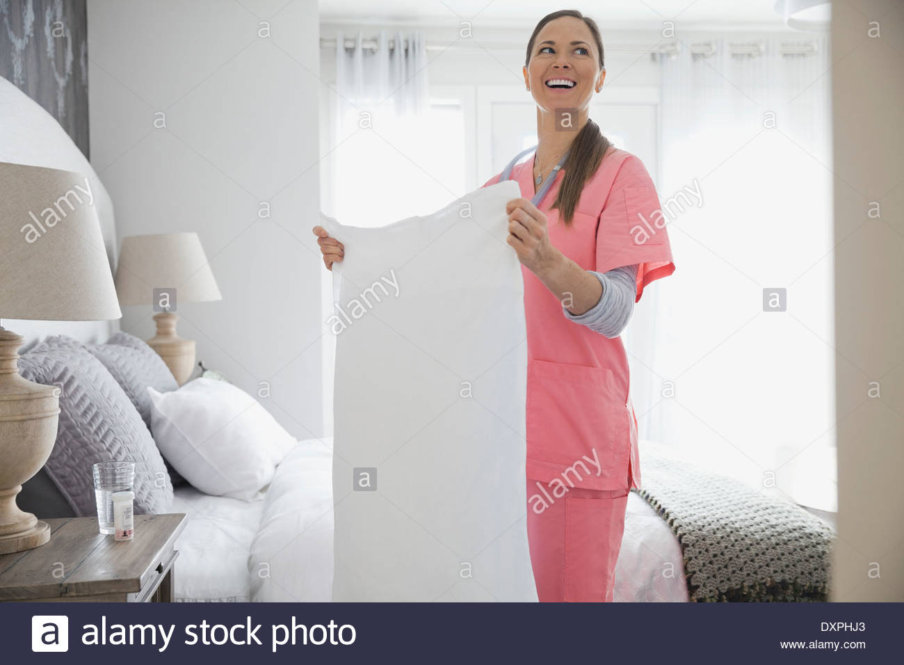 Home nurse making patients bed Stock Photo Alamy