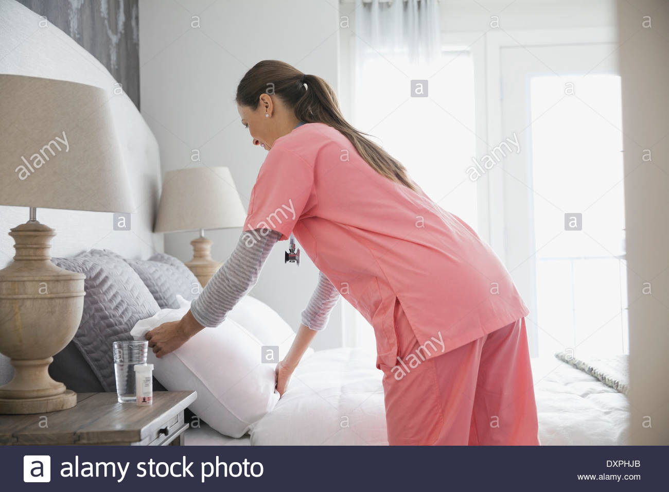 Home nurse making patients bed Stock Photo Alamy