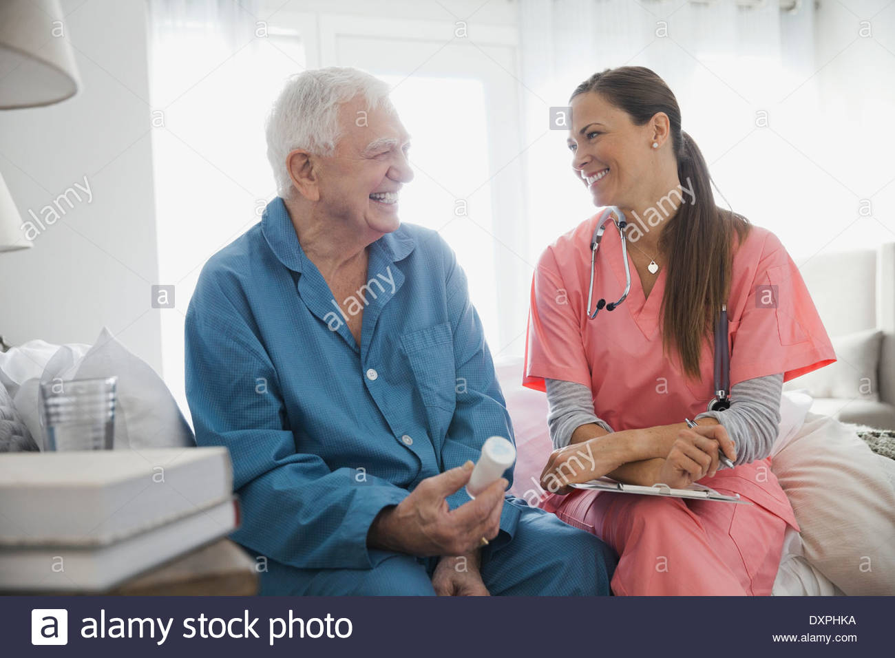 Home care nurse sitting with senior patient Stock Photo