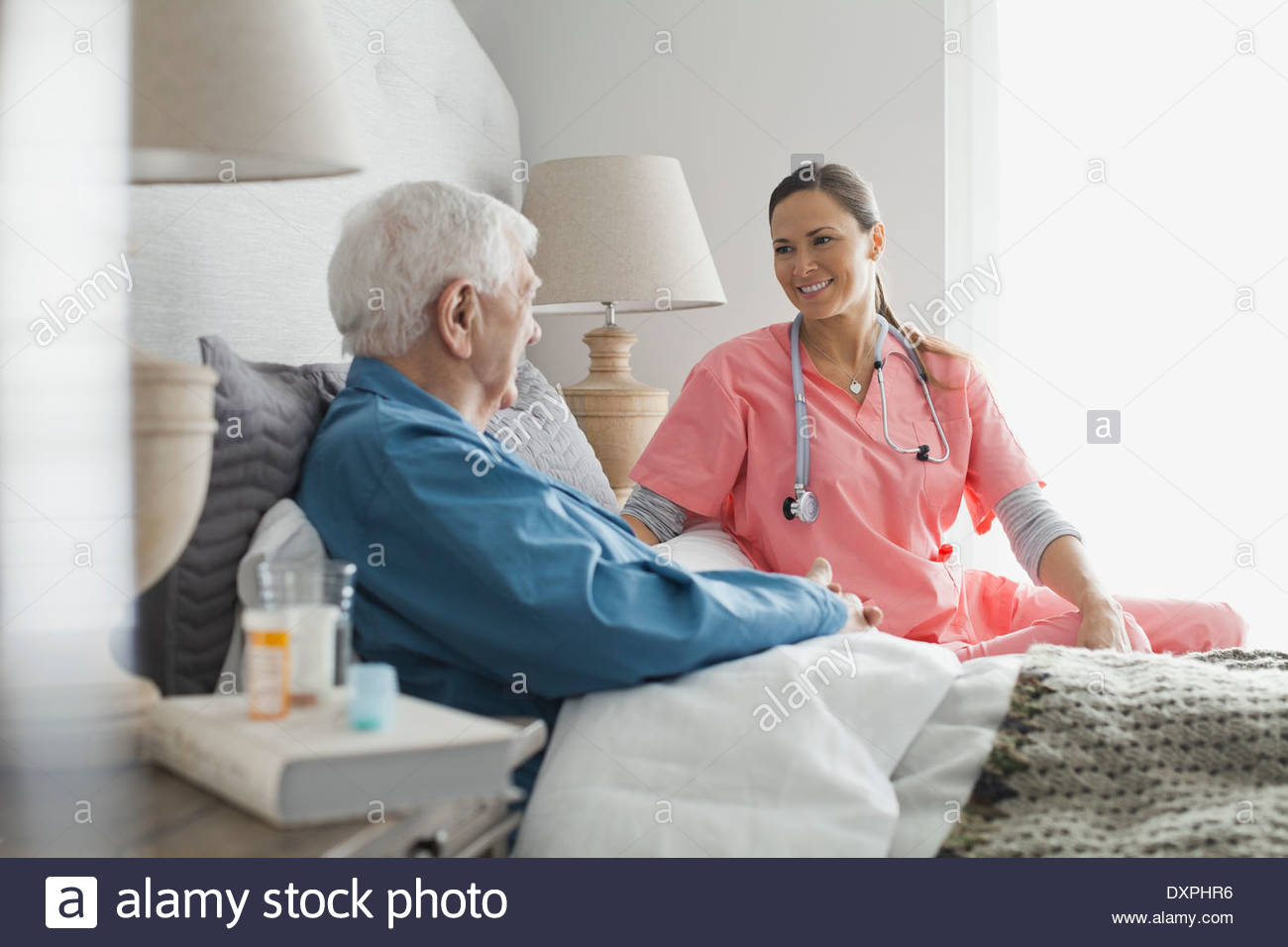 Home care nurse sitting with senior patient Stock Photo