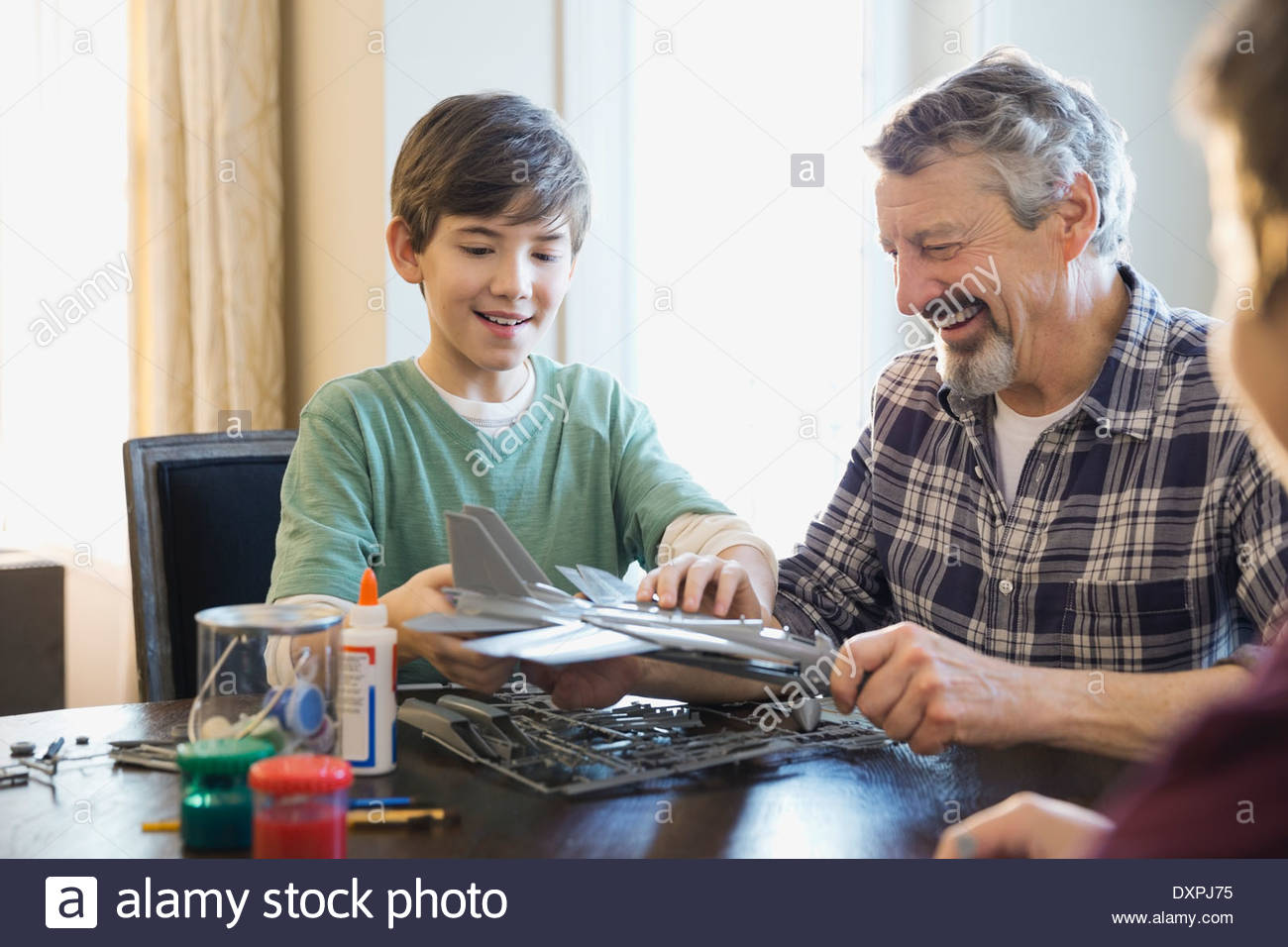 Grandfather and grandsons making airplane model at home Stock Photo
