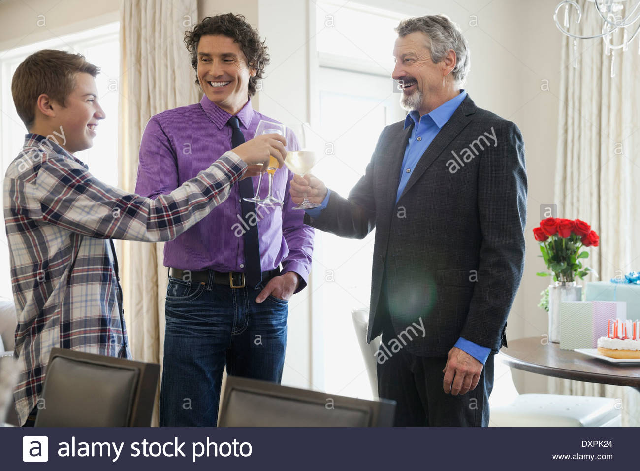 Men toasting wineglasses at home Stock Photo