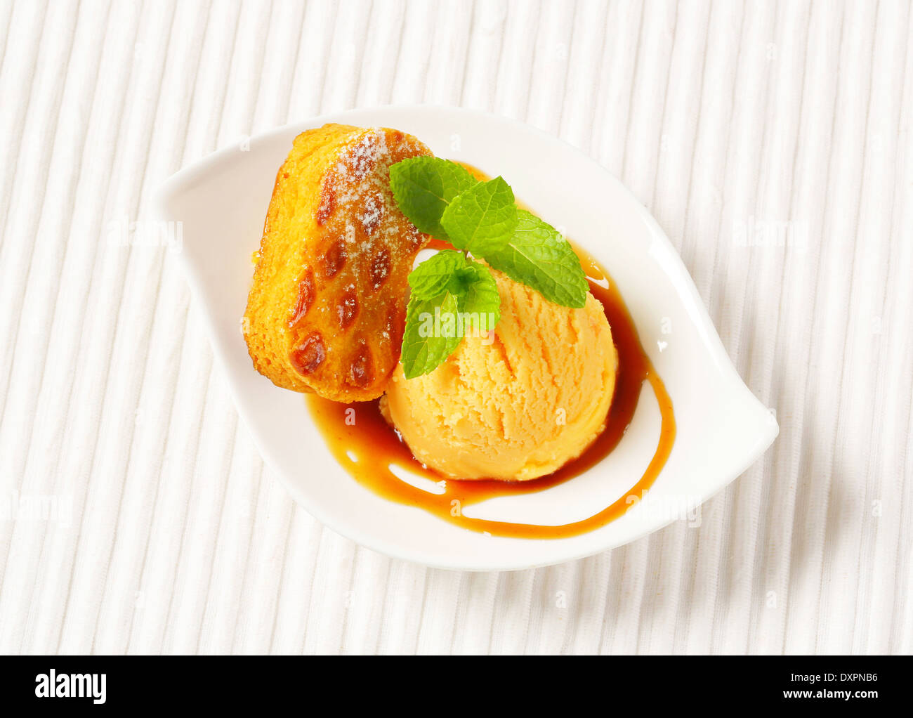 Small Dutch oval-shaped cake (Roomboter kano) with ice cream and caramel syrup Stock Photo