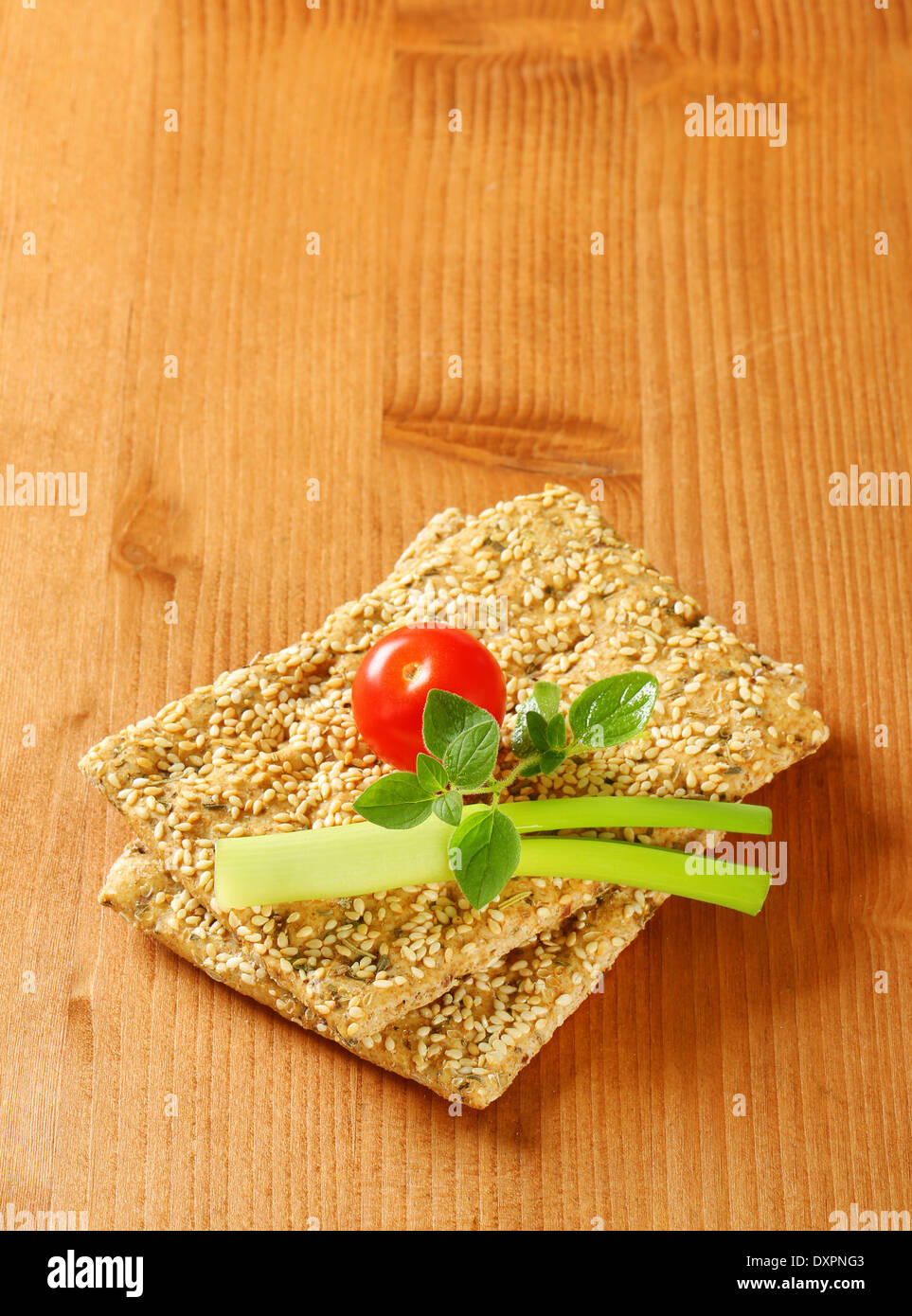 Whole wheat crackers with sesame seeds and chopped herbs Stock Photo