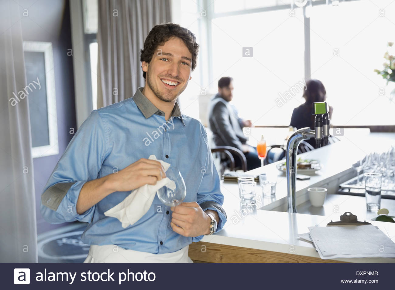 Portrait of bartender drying wine glass in bar Stock Photo Alamy