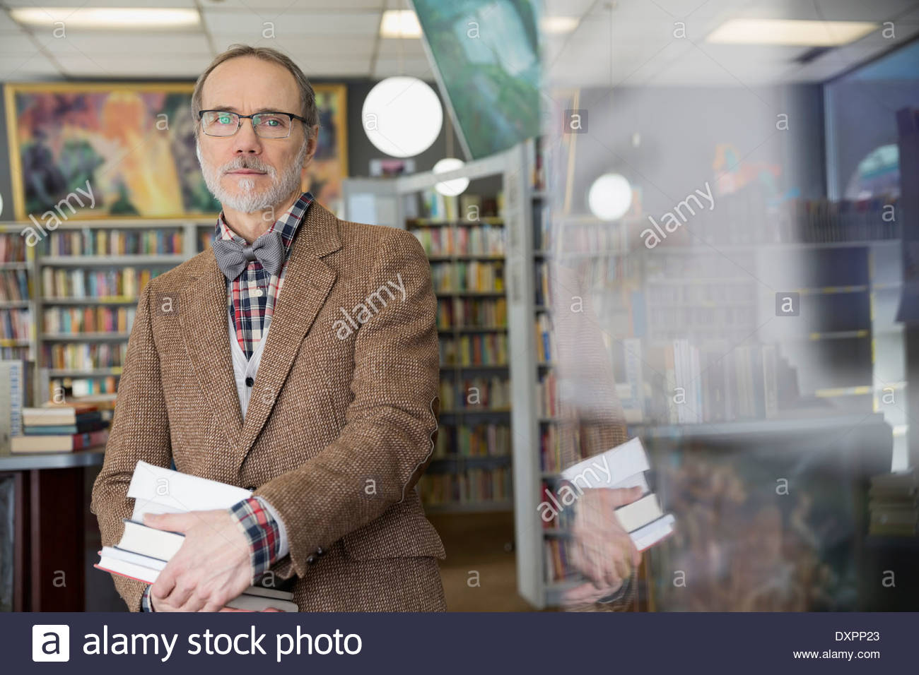 Portrait of man holding books in bookstore Stock Photo Alamy