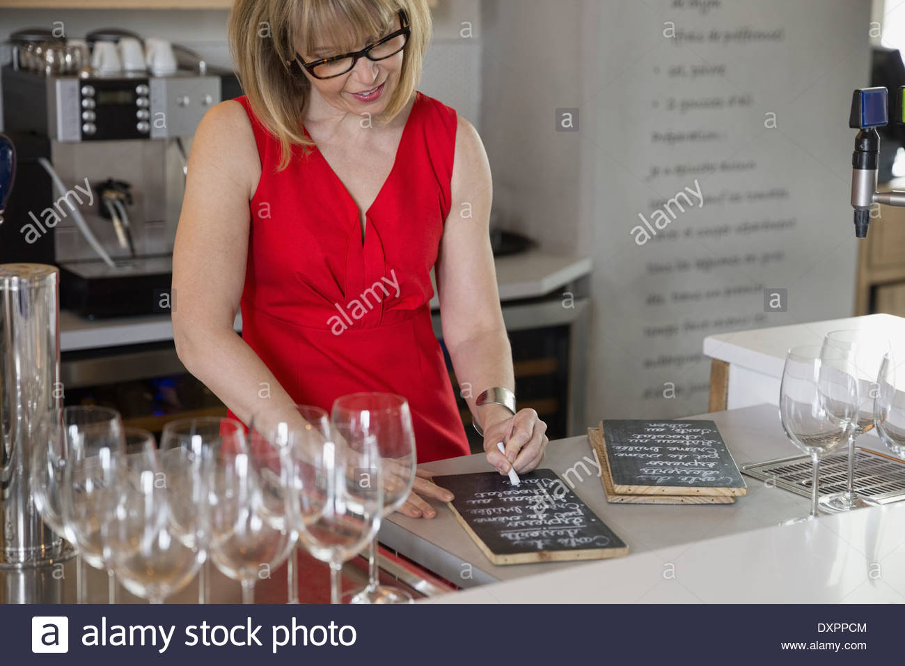 Bistro owner writing menus on blackboards Stock Photo