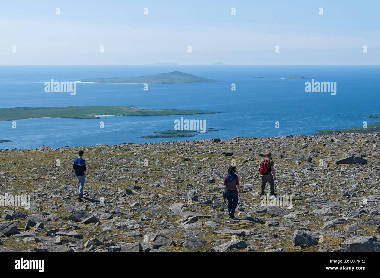 Walkers on the summit of Roineabhal (460m) near Leverburgh, South Harris hills, Western Isles, Scotland, UK.  St. Kilda just visible on the horizon. Stock Photo