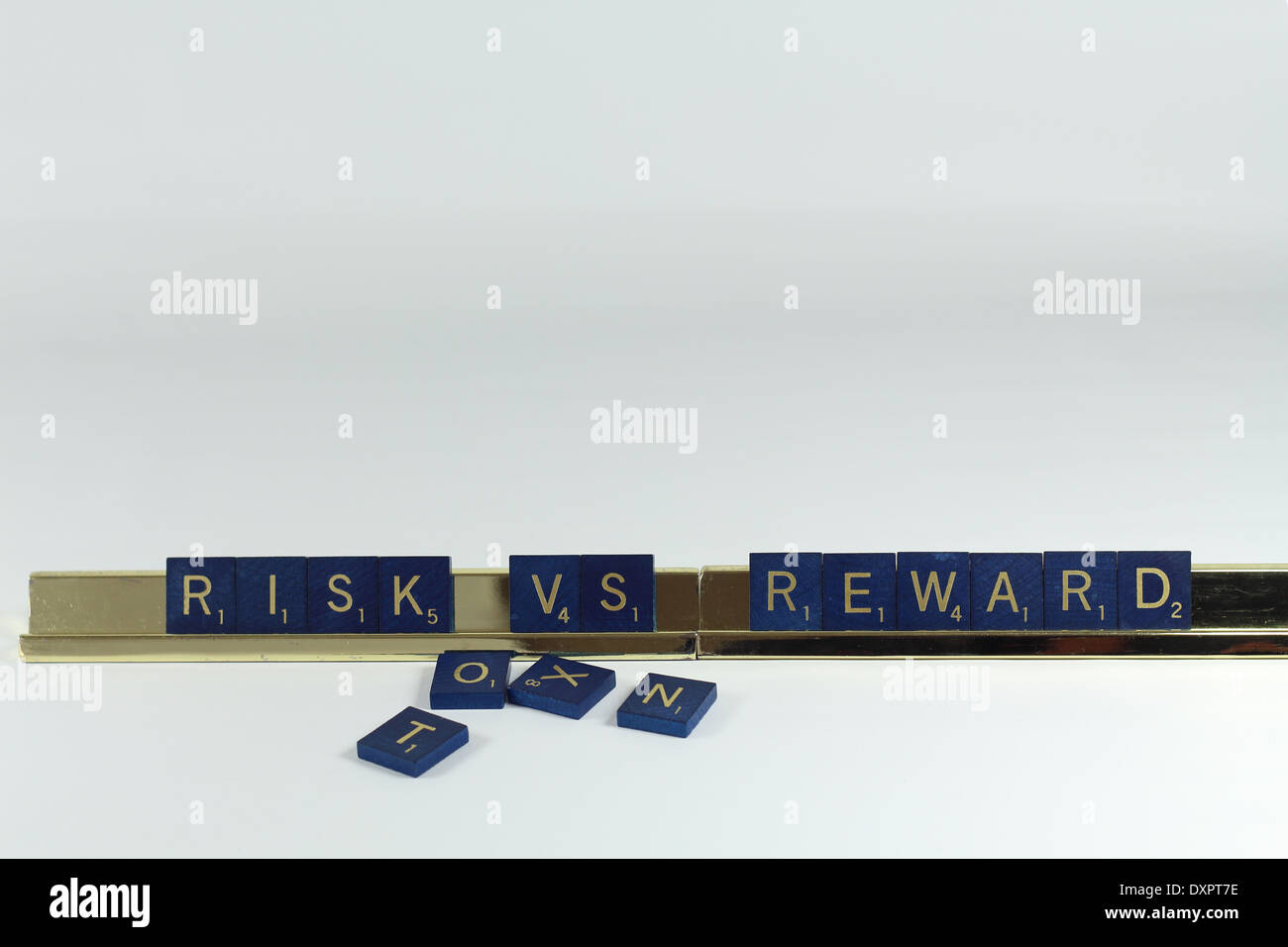 Risk versus reward tiles on a gold stand on white background Stock ...