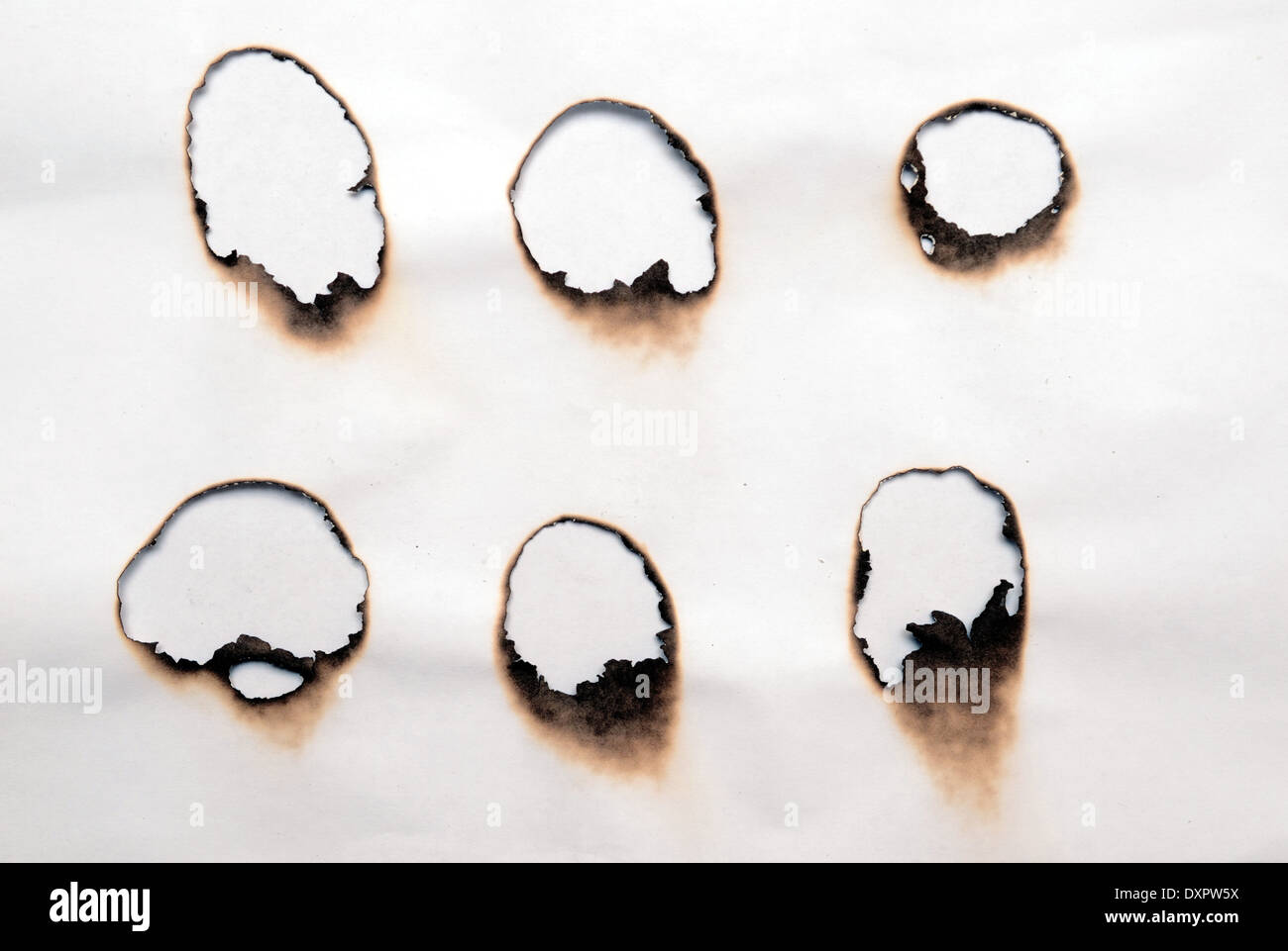 burnt holes in a paper Stock Photo Alamy