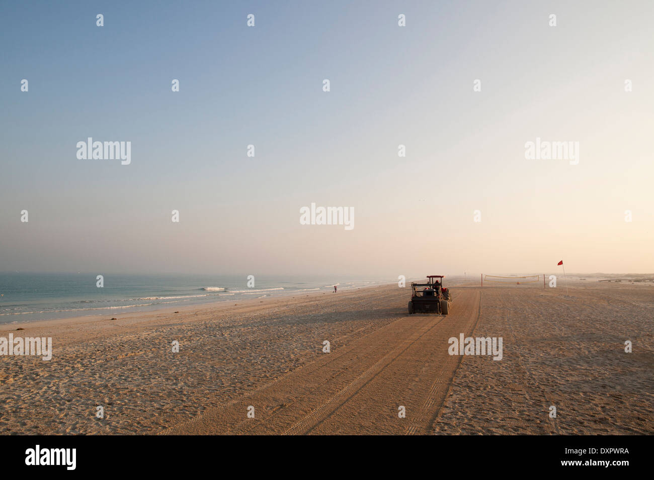A tractor cleans and grooms the Arabian gulf beach on Saadiyat Island, Abu Dhabi, United Arab Emirates. Stock Photo