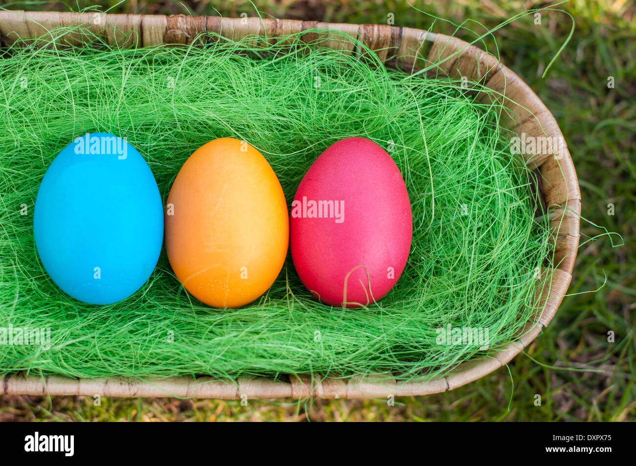 Tree Easter Eggs in a basket on a grass Stock Photo