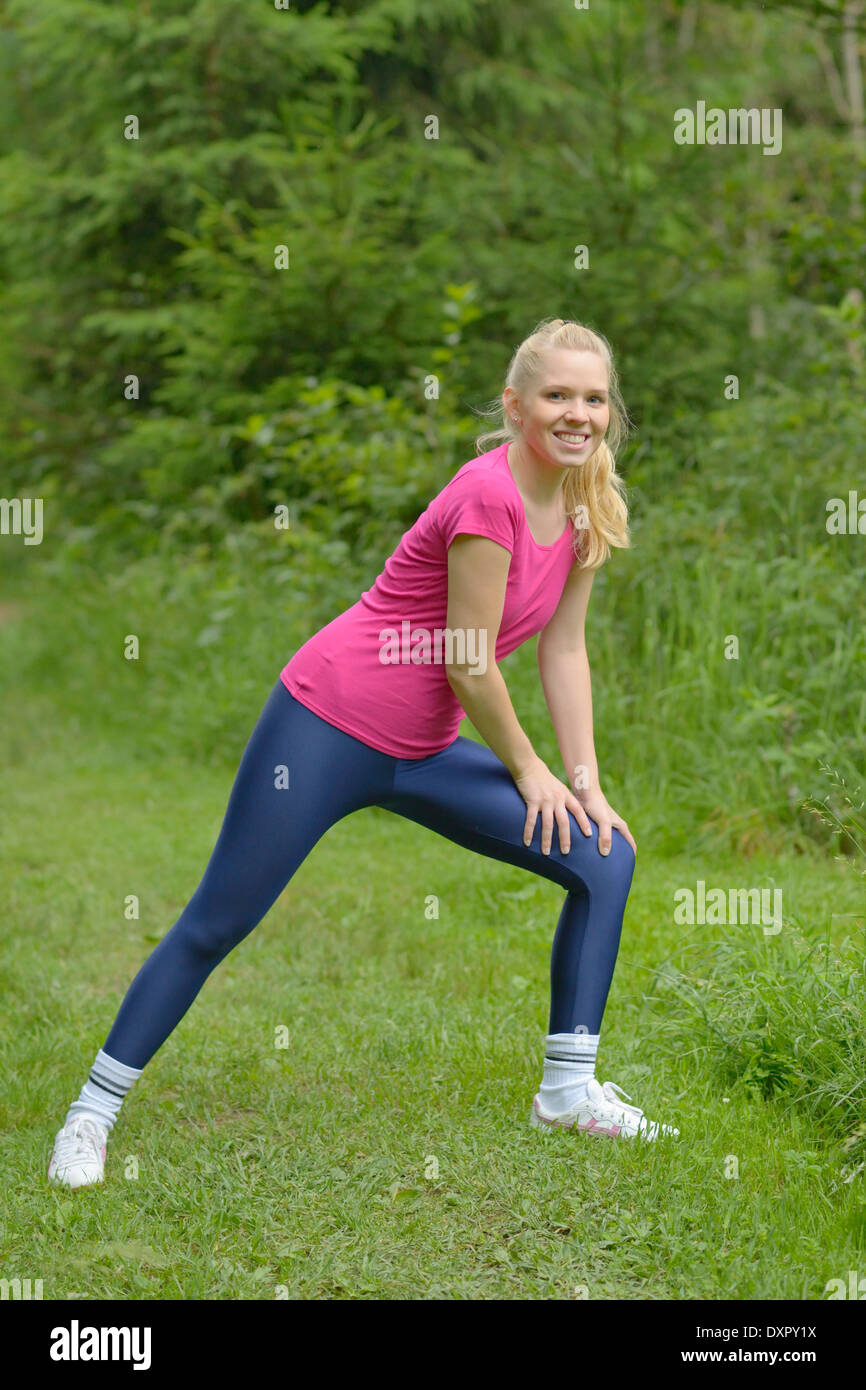 Jogger wearing leggings made from shiny spandex, Stretching