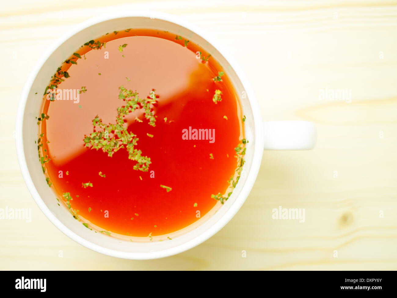 Tomato soup is bright red, orange with spices, herbs in a white cup Stock Photo