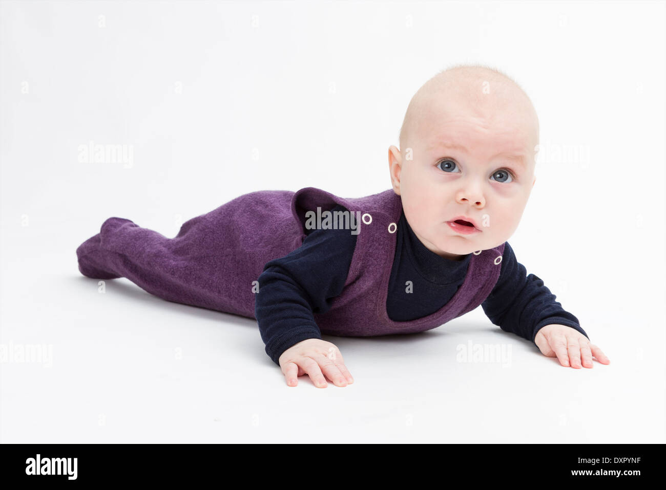 baby on floor looking to camera. studio shot in grey background Stock Photo