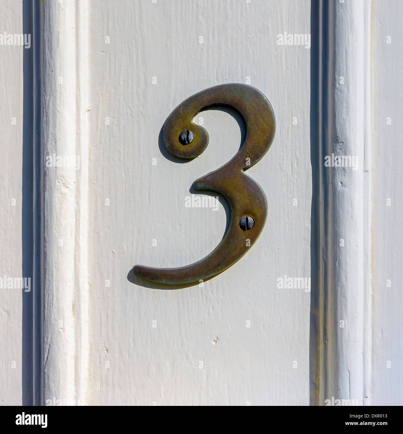 Bronze house number three attached to a wooden panel Stock Photo Alamy