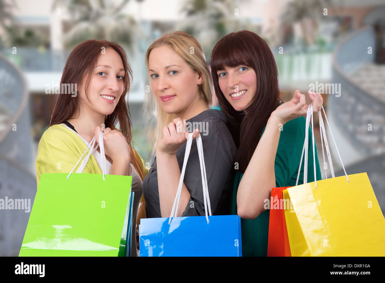 Group of smiling young women with shopping bags having fun while shopping in a shopping mall Stock Photo