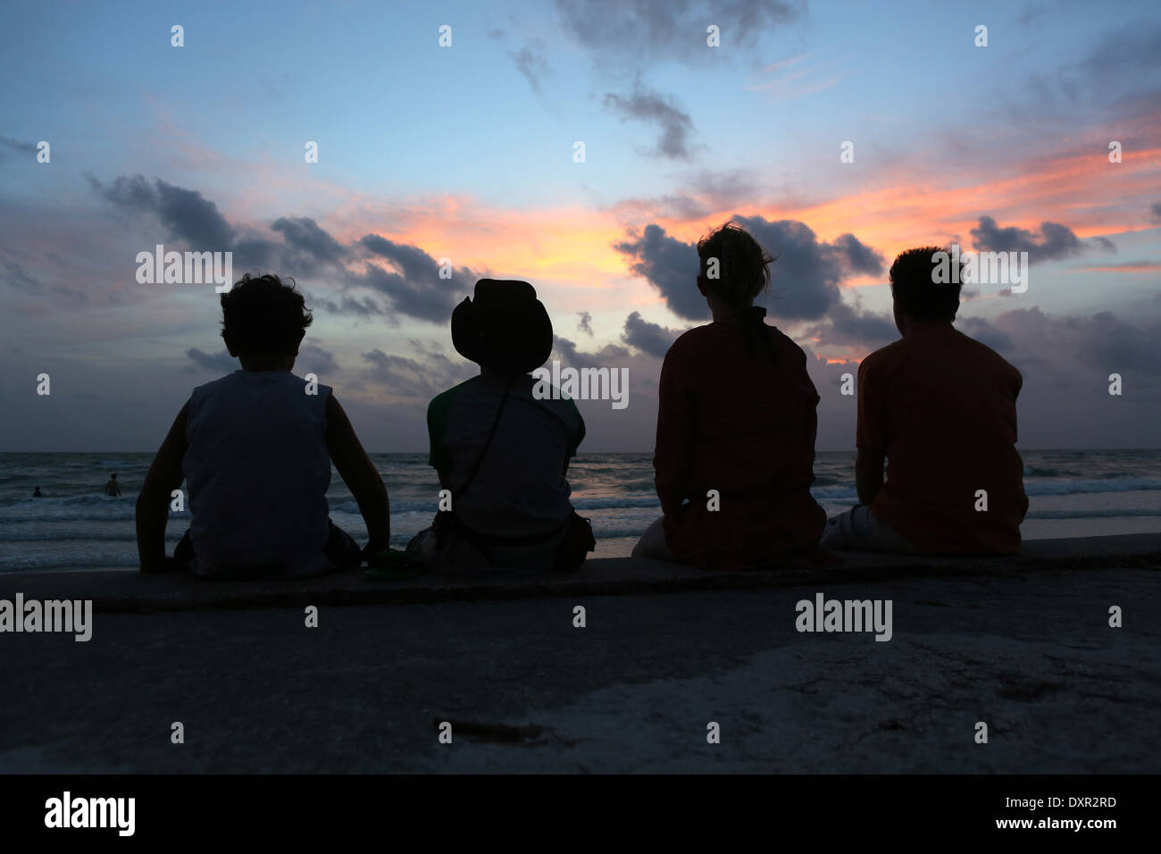 Pass A Grille, United States of America, Silhouette, Family sitting at dusk on the beach Stock Photo